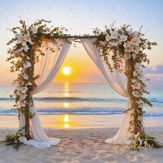 an outdoor wedding set up on the beach with white flowers and greenery at sunset