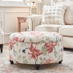 a living room filled with furniture and a flower covered ottoman