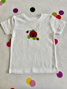 Darling ladybugs adorn this embroidered toddler size t-shirt. Size 24 months 100% cotton.  Soft backing inside Ladybug Design, Embroidered T Shirt, Embroidered Tshirt, Toddler Sizes, Gender Neutral Baby, Embroidered Shirt, Sleeve Cotton, Baby Bodysuit, Baby Clothes