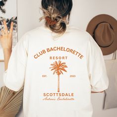 the back of a woman's white shirt that reads club bachelor resort scottsdale