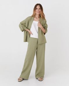 This throw-on linen kimono jacket BANOS in sage offers an effortlessly chic look with its open front, shawl collar, and relaxed dropped shoulders. The 3/4 sleeves feature decorative flaps at the bottom, which can be secured with coconut buttons, adding a unique touch to the design. Details: * Loose fit * Shawl collar * Non-closable * 3/4 sleeve length * Dropped shoulder design * Bottom of the sleeves that fastens with decorative coconut buttons * Centre back length: 23" (58cm) * The model is wea Summer Green Linen Blazer, Spring Green Linen Blazer, Green Linen Summer Outerwear, Green Linen Spring Outerwear, Spring Green Linen Outerwear, Spring Casual Linen Kimono, Casual Linen Kimono For Spring, Casual Linen Kimono With Relaxed Fit, Linen Kimono