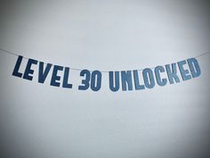 a banner that reads level 30 unlocked hanging from a string in front of a white wall