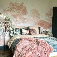 a bedroom with pink and blue decor on the walls, bedding and rugs