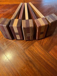 four pieces of wood sitting on top of a wooden floor