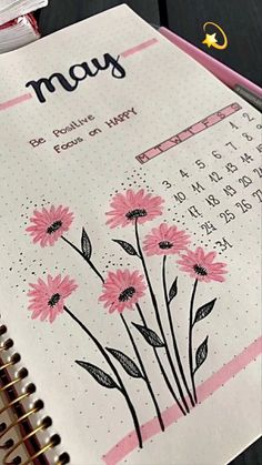 a planner with pink flowers on it and the word may written in cursive writing