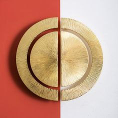 a gold plate sitting on top of a red and white wall