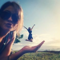 a woman is flying through the air with her hands in front of her and another person holding