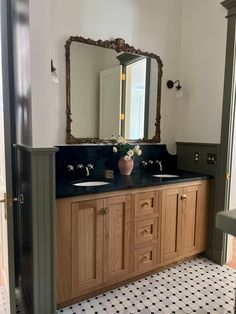 a bathroom with two sinks and a large mirror