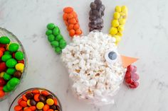 a turkey made out of candy and marshmallows next to a bowl of candies