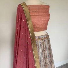 Peach silk fabric with a hint of pink coming through in the blouse/choli fabric. A light two tone affect , Vintage vibe lahenga skirt in antique embroidery in thread work, small matt sequence, aari and jardosi work.  It's absolutely breathtaking in real Dusky pink dupatta with an antique bronze dupatta border The blouse material can be stitched as per your convenience and your style preference at your local tailor. Navratri Pink Embroidered Fabric With Motifs, Pink Embroidered Fabric With Motifs For Navratri, Semi-stitched Pink Brocade Choli, Pink Semi-stitched Brocade Choli, Bohemian Unstitched Lehenga For Transitional Season, Pink Embroidered Semi-stitched Fabric With Motifs, Bollywood Style Pink Embroidered Fabric With Motifs, Pink Bollywood Style Embroidered Fabric With Motifs, Pink Brocade Sharara For Navratri