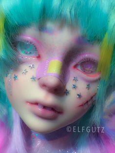 a close up of a doll with colorful hair and makeup