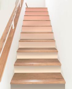 a set of stairs with wooden handrails and beige painted steps leading up to the second floor