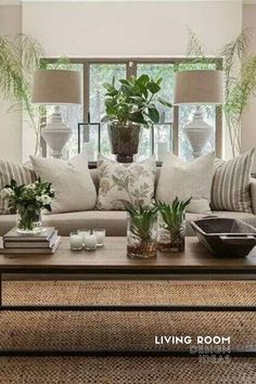 a living room filled with lots of furniture and plants on top of a coffee table