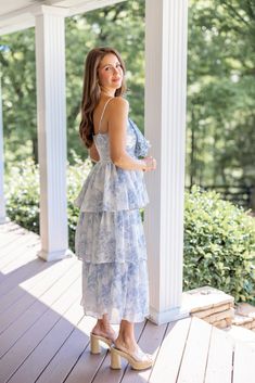 Light blue floral print layer tiered midi dress with decorative bow on bodice You will feel just like a princess in this Sweet Florals Blue Midi Dress! She's so delicate, and pretty with white and light blue floral print, large bow on the ruched bodice, and layer tiered skirt. The perfect Summer dress for all of your upcoming celebrations - from Wedding events to summer vacations and everything in between! Fits true to size; flowy skirt Model is 5'5" wearing a small Fabric contains slight stretc Blue Tiered Midi Dress With Floral Print, Light Blue Ruffled Midi Dress For Garden Party, Blue Floral Print Tiered Skirt Dress, Blue Midi Dress With Ruffled Straps For Garden Party, Blue Floral Print Dress With Tiered Skirt, Feminine Blue Tiered Skirt Dress, Feminine Blue Tiered Dress, Light Blue Tiered Skirt Dress For Spring, Feminine Blue Tiered Midi Dress