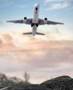 an airplane is flying in the sky over some rocks