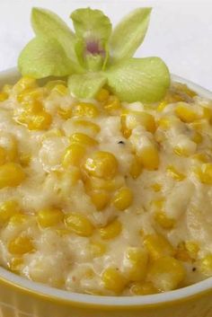 a yellow bowl filled with corn and a green flower