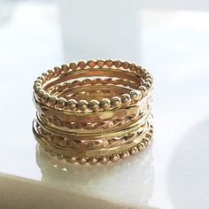 "This ring set is beautifully made to wear every day. Stackable ring set exactly the combination that is shown. Wear together stacked or a few on different fingers. I make each and every set just for you as ordered. If you need special sizes please contact before ordering. M A T E R I A L 14k Yellow Gold Filled S E T ⋯ I N C L U D E S 2 hammered bands 2 twist bands 2 eternity ball bands 1 smooth band S I Z E S 5, 6, 7, 8, 9, or 10 This set includes 7 rings in all the same size. D E T A I L S Our Unique Hand Forged Gold Stackable Rings, Unique Handmade Gold Stackable Rings, Stacked Yellow Gold Round Jewelry, Stacked Round Yellow Gold Jewelry, Stacked 14k Gold Rings As Gift, Stacked Rings In 14k Gold As Gift, Stacked 14k Gold Rings For Gift, Handmade Gold Stackable Rings For Wedding, Unique Gold Stackable Rings For Gift