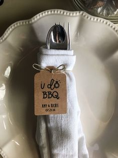 a white plate topped with a fork and knife next to a tag that says u do bbq