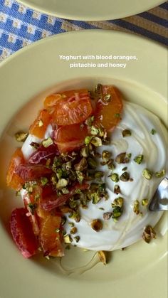 yogurt with blood oranges, pistachio and honey on two plates