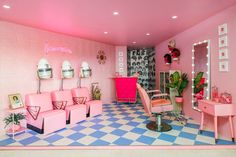 a room with pink furniture and decorations on the walls