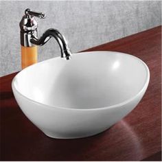 a white bowl sink sitting on top of a wooden counter next to a faucet