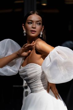 a woman in a white dress posing for the camera