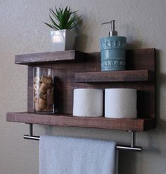 two wooden shelves with towels, toilet paper and other bathroom items on top of them