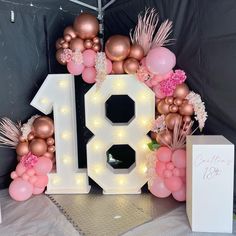 the number eighteen is surrounded by balloons, flowers and other decorations for a birthday party