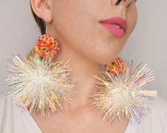 a woman wearing large earrings with sprinkles on them