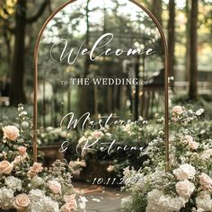 an arch decorated with flowers and greenery for a welcome sign to the wedding ceremony