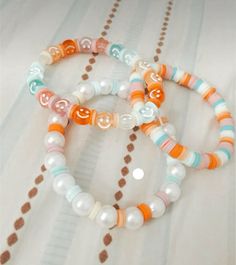 three bracelets with different colored beads on them