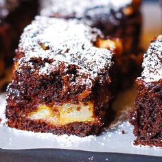 some brownies are sitting on a table with powdered sugar