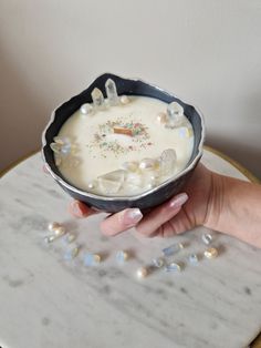 a person holding a bowl filled with white liquid