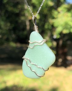 "A GENUINE jadeite Sea Glass has been wire wrapped with sterling silver to create this beautiful pendant. This beautiful handmade pendant is one of kind sea glass jewelry. The pendant comes with a 20\" long box sterling silver chain free of charge or for a small extra charge with a silk cord with sterling silver clasp. You will receive the same piece as in the photo. Size: Sea Glass Size - 1& 1/4\" (3.0 cm) long x 3/4\" (2.0cm) wide Pendant size - 1& 3/4\" (4.0 cm) long Metal: Sterling S Elegant Green Sea Glass Jewelry, Green Sea Glass Wire Wrapped Jewelry, Sea Glass Large Pendant Necklace, Adjustable Ocean-inspired Sea Glass Jewelry, Hand-wrapped Sea Glass Jewelry For The Beach, Sea Glass Pendant, Silk Cord, Sea Glass Jewelry, Handmade Pendants