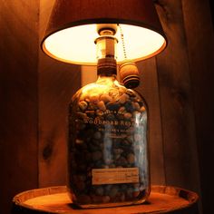 a lamp that is sitting on top of a wooden table next to a bottle filled with rocks