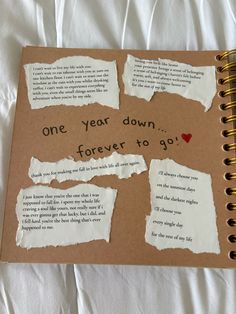 a note book with torn paper and some words on the pages that read one year down, forever to go