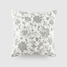 a white and grey floral pillow on a gray background