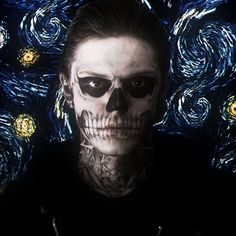 a man with his face painted like a skull in front of a starry background