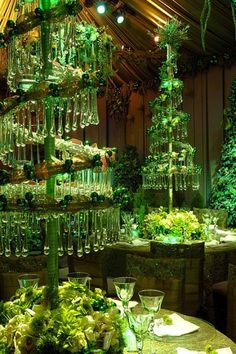 a table topped with lots of green plants and wine glasses