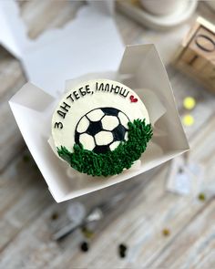 a cupcake decorated with grass and a soccer ball