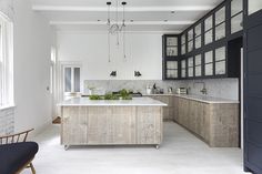 a large kitchen with marble counter tops and wooden cabinetry, along with black cabinets