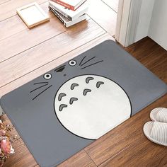 a door mat with a cat face on it in front of a pair of shoes