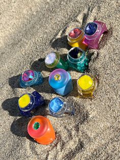 there are many different colored cups in the sand