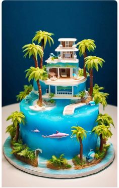 a cake that is shaped like a house on the beach with palm trees and dolphins