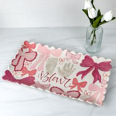 a pink and white tray with hand prints on it