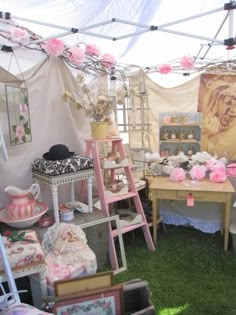 there are many items on display in this tented area, including tables and chairs