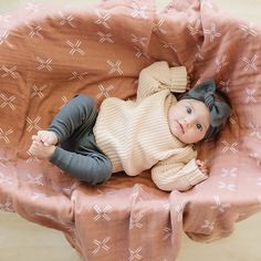 a baby laying on top of a pink blanket