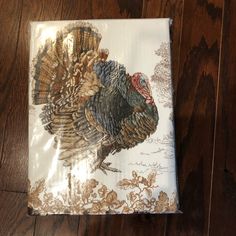 a napkin with a turkey on it sitting on top of a wooden floor next to a knife