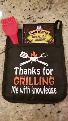 there is a black pot holder with red utensils and a pink spatula in it