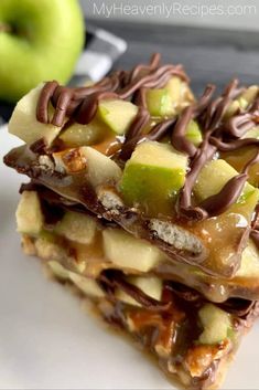 two pieces of fruit and nut bars on a plate with an apple in the background